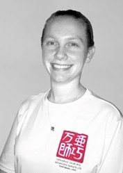 Young adult woman in white t-shirt, smiling at camera, grey background